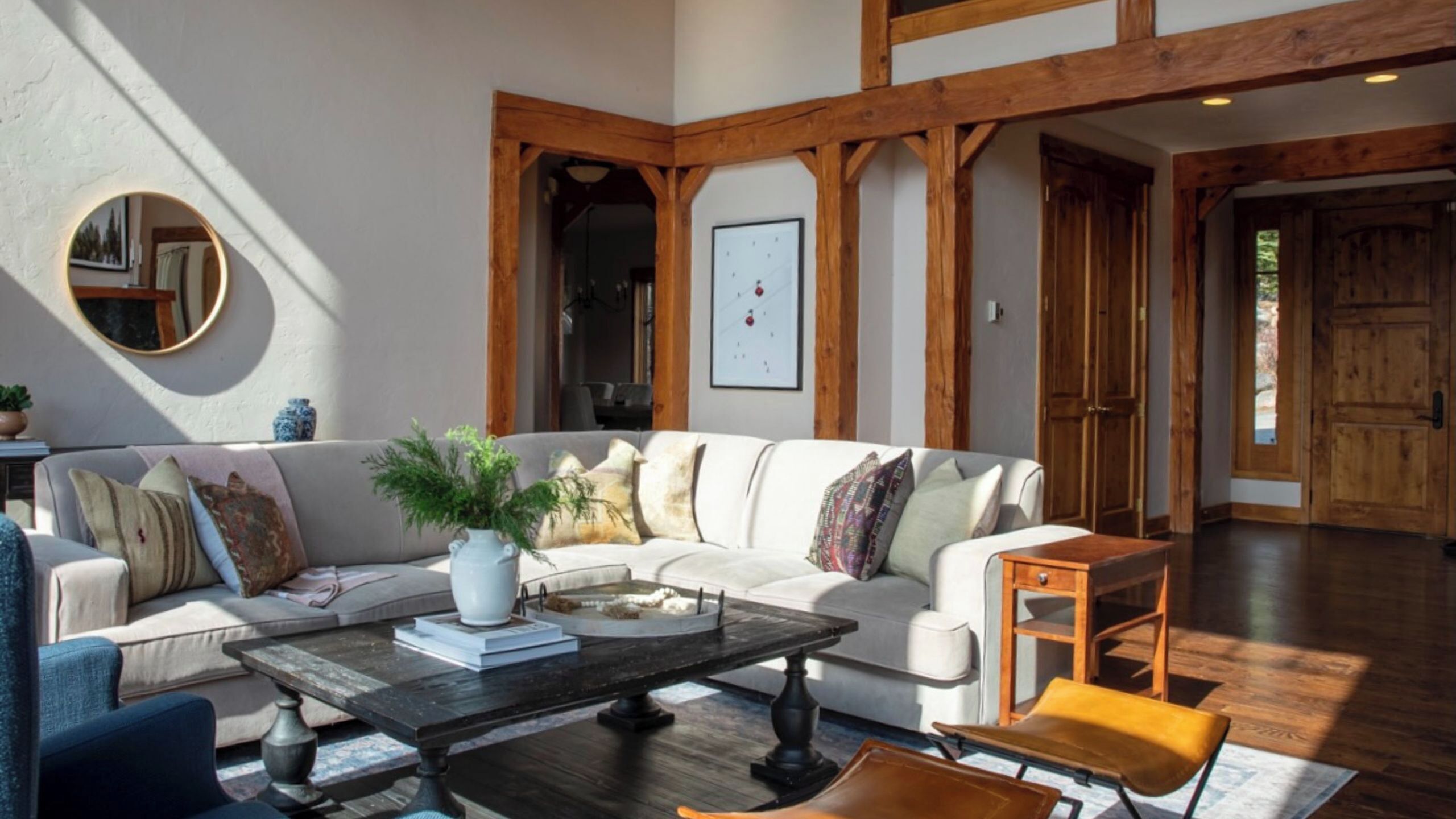 A modern living room with a white sofa, a coffee table, and a wooden bench.
