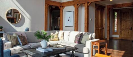 A modern living room with a white sofa, a coffee table, and a wooden bench.