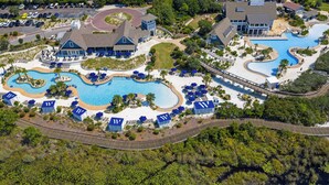 An aerial view of a resort with multiple swimming pools, lounge areas, and a variety of buildings.