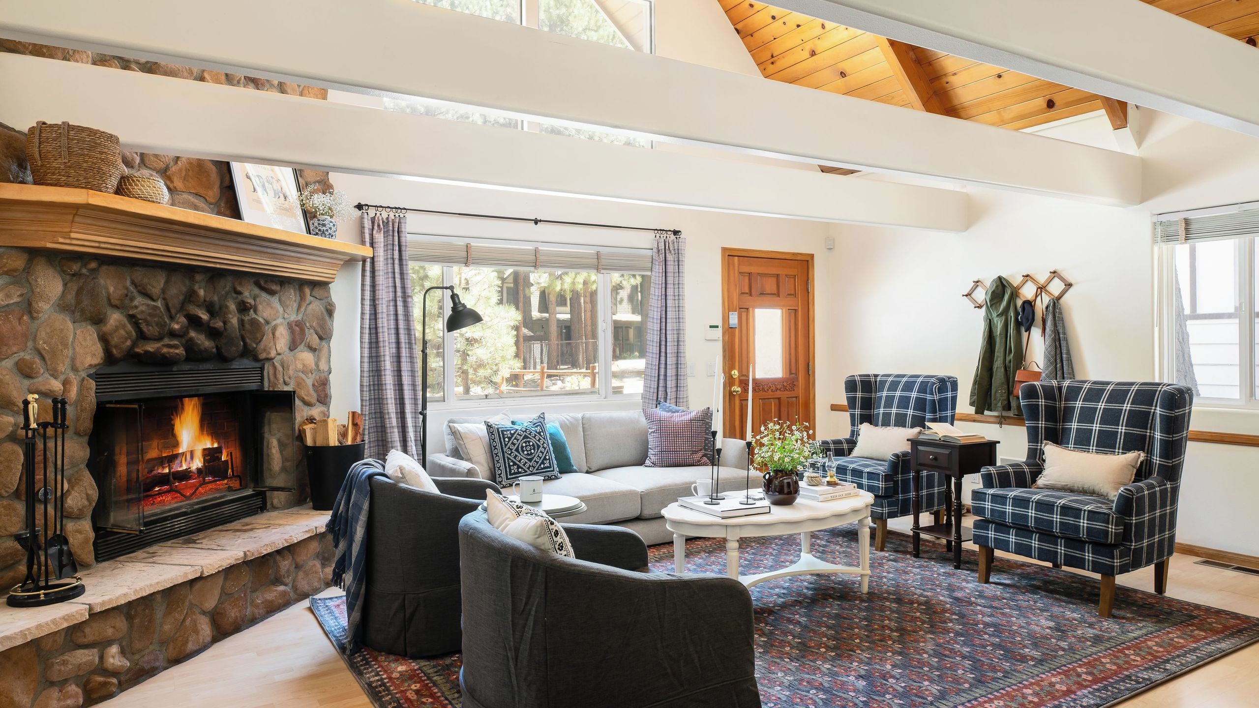 Una sala de estar acogedora con chimenea de piedra, asientos cómodos y vistas al exterior.