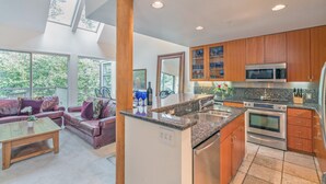 Eine moderne Küche mit Granit-Arbeitsplatten, Edelstahlgeräten und Holzschränken.