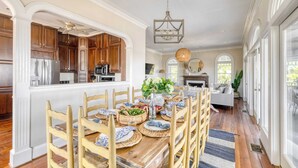 A spacious kitchen with wooden cabinets, a stainless steel refrigerator, and a dining area with a wooden table set for six.