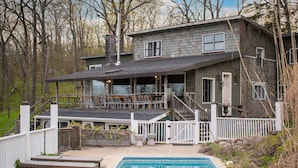 A two-story house with a pool, wooden deck, and a covered patio area. - Shakespeare on the Hudson by Avantstay Two Home Buyout on the Hudson River! 22 Bedrooms! (Catskill)