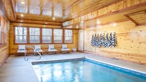 Una cabana de fusta amb piscina, parets de fusta i finestres.