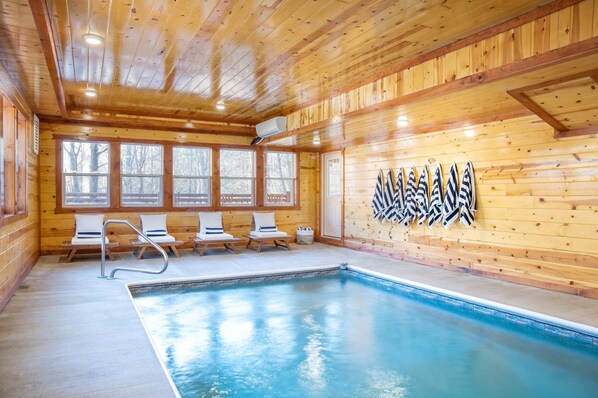 A wooden cabin with a pool, wooden walls, and windows.