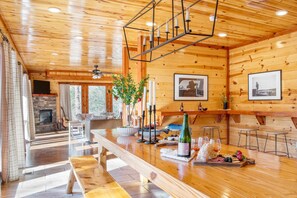 A wooden interior with a dining area, fireplace, and bar. - Sycamore by Avantstay Spectacular Mountain Home w/ Indoor Pool, Hot Tub, Home Theatre & Fire Pit! (Sevierville)