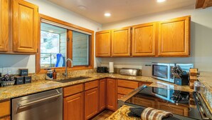 A modern kitchen with wooden cabinets, stainless steel appliances, and granite countertops. - Riverside Condos C102 by Avantstay Condo Close To Downtown, Town Park & Ski Lift #8 (Telluride)