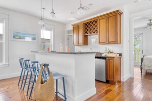 Una cocina moderna con armarios de madera, una isla central y taburetes de bar.