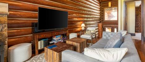 Ein Blockhaushaus-Interieur mit Fernseher, Sofa und Holzmöbeln.