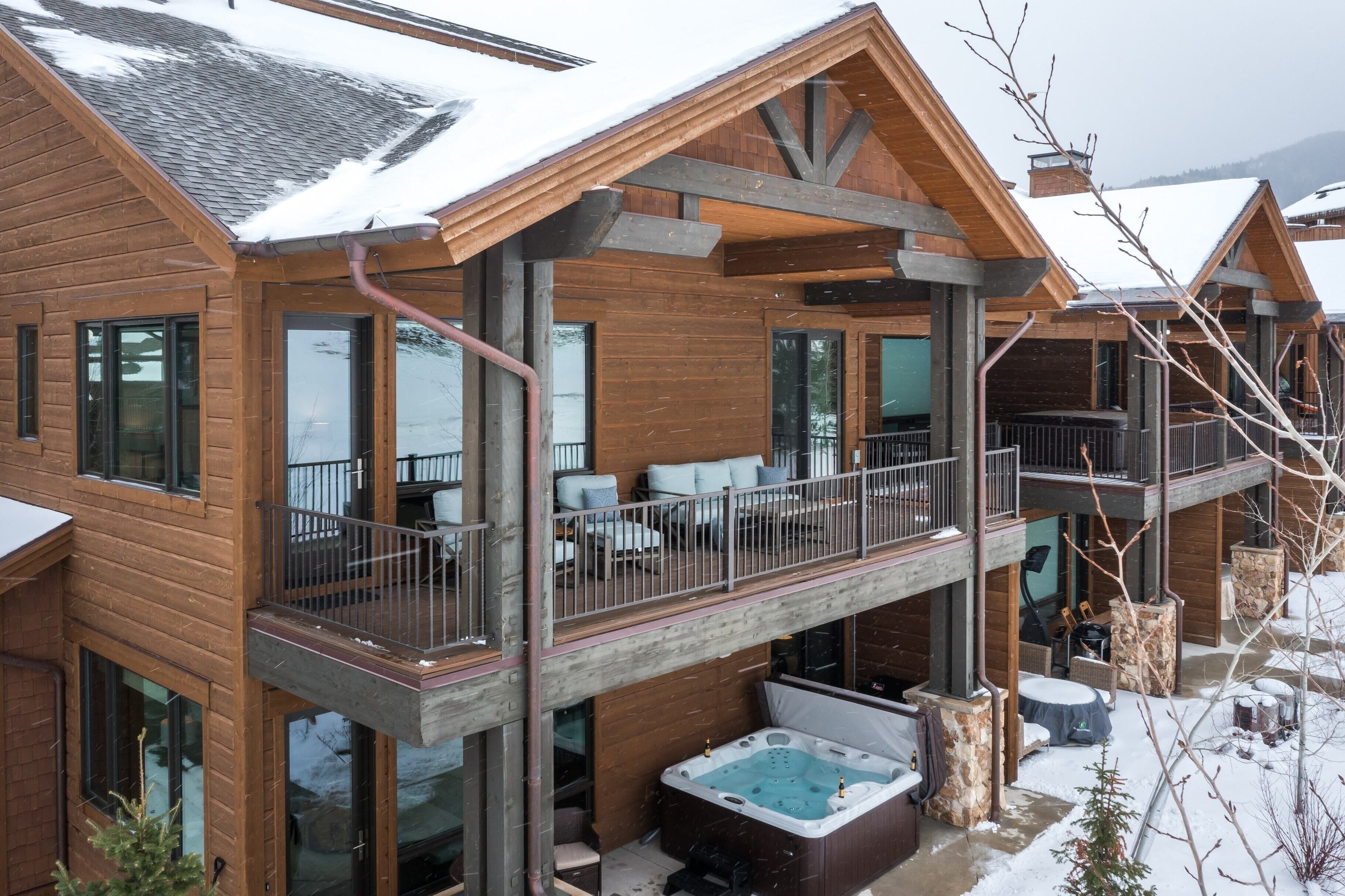 Eine Holzdiele mit Balkon, Whirlpool und überdachter Sitzgelegenheit im Freien.