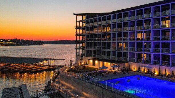 Un hotel con piscina, area salotto esterna e vista sull'acqua.