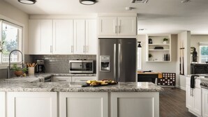 A modern kitchen with white cabinetry, a stainless steel refrigerator, a built-in oven, and a marble countertop. - Private Temecula Wine Country Estate With Pool, Hot Tub, Mini Golf & Stunning Patio (Temecula)