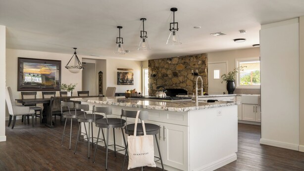 A modern kitchen with a large island, bar stools, a stone accent wall, and pendant lighting. - Private Temecula Wine Country Estate With Pool, Hot Tub, Mini Golf & Stunning Patio (Temecula)