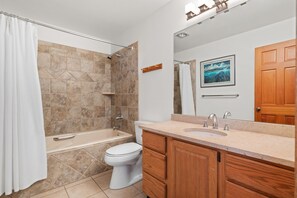 A bathroom with a bathtub, toilet, and vanity with a sink. - Riverside Condos A103 by Avantstay Condo Close To Downtown, Town Park & Ski Lift #8 (Telluride)