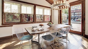 A dining area with a wooden table, wire chairs, and a chandelier. - Modern 5bdr Right off Main Street w/ Hot Tub Main Street Escape by Avantstay (Park City)