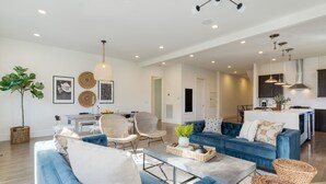 A spacious living area with a blue sofa, wicker chairs, and a coffee table.
