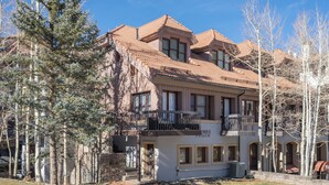 A two-story building with a balcony, a sign reading 'Columbia Place,' and a restaurant sign 'Sushi & Salads.' - Columbia Place 5 by Avantstay Ski-in/ski-out Unit in Great Location! (Telluride)