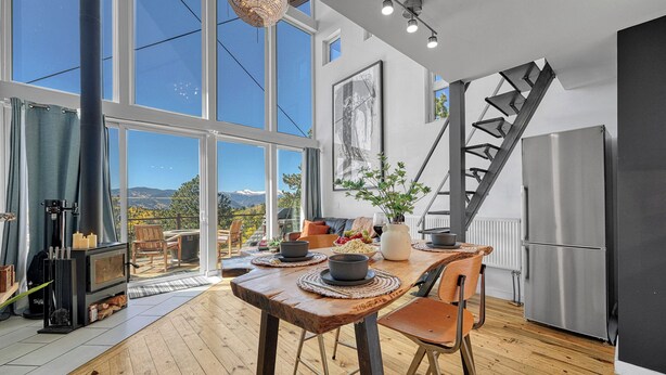 A modern kitchen with a wooden table, a built-in stove, and a stainless steel refrigerator. - Off-grid Masterpiece Cabin W/ Breathtaking View (Central City)