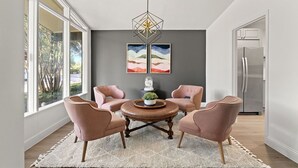 A modern dining area with a round table, four pink chairs, a white rug, and two framed artworks on the wall. - 3 bdrm Sanctuary in the Heart of Dallas (Dallas)