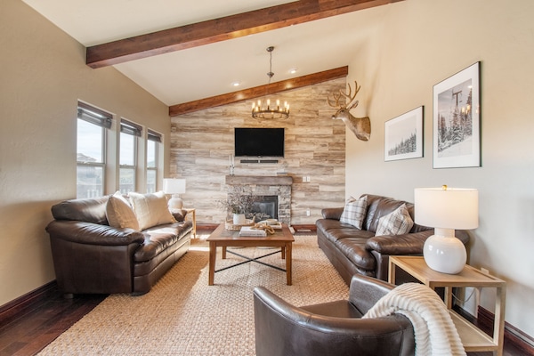 Living room features a fireplace, TV, and two sofas.