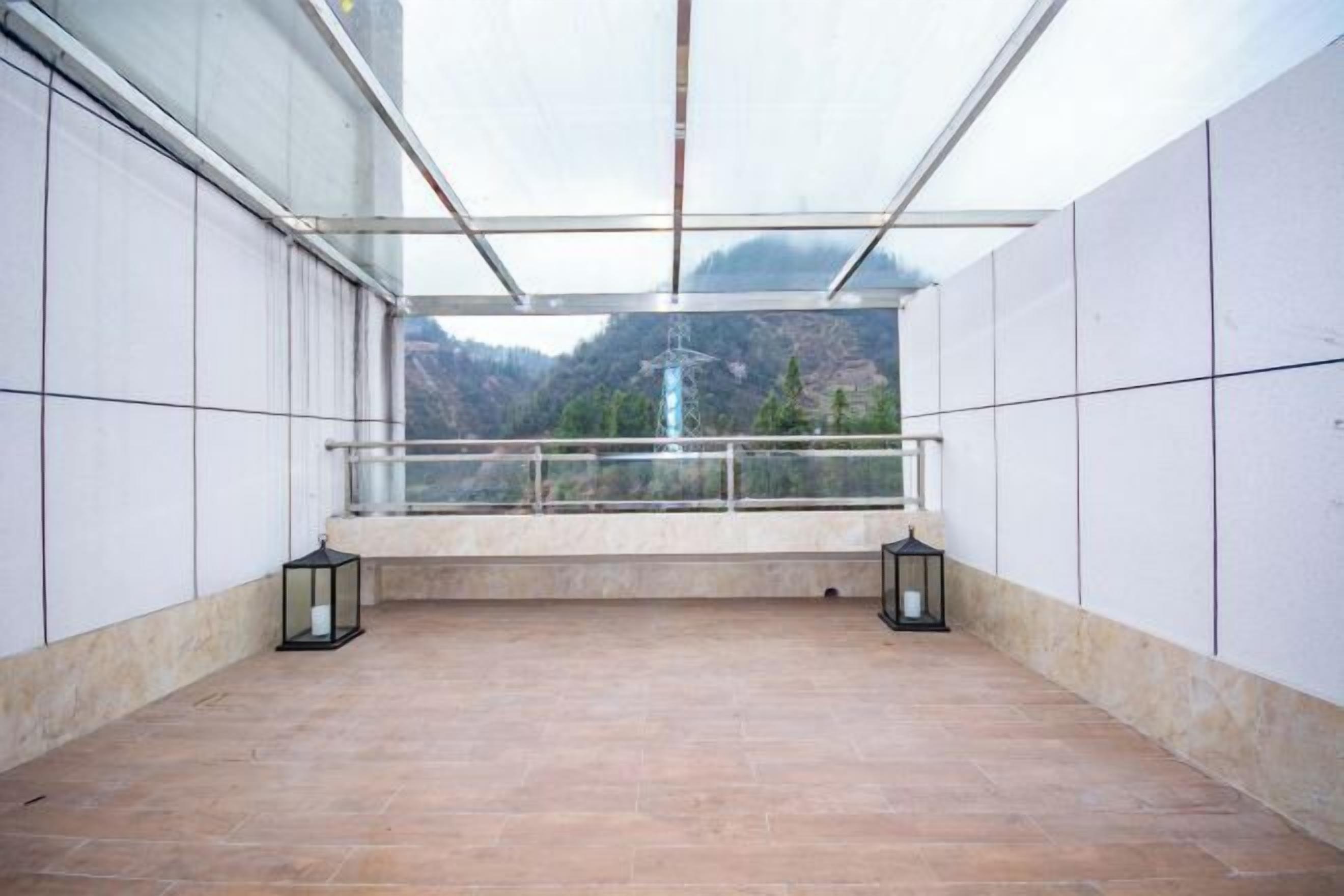 A balcony with a view of mountains and a power line.