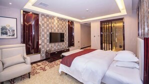 A hotel room with a bed, a TV, a sofa, and a patterned wall. - Yesanguan International Hotel (Badong)