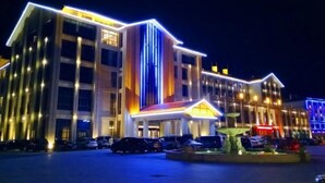 A multi-story hotel with a modern design, featuring a prominent entrance with a lighted facade and a central fountain. - Yesanguan International Hotel (Badong)