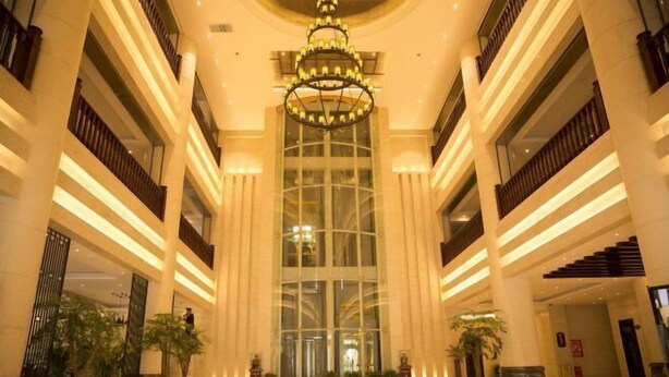 A spacious lobby with a grand chandelier, tall columns, and multiple floors. - Yesanguan International Hotel (Badong)