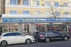 Un edificio con varias fachadas comerciales, incluyendo una farmacia y una tienda de conveniencia.