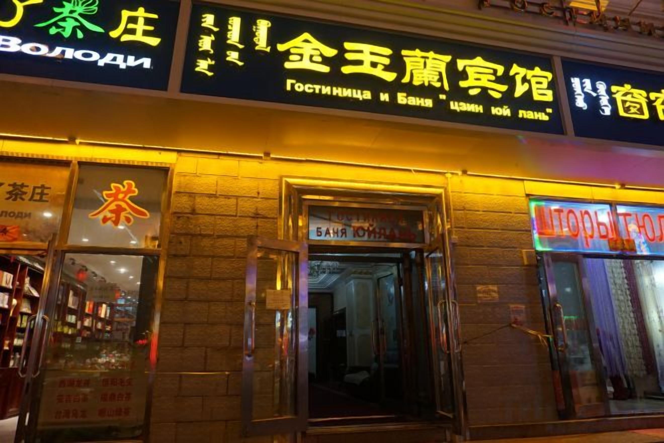 A building with a storefront featuring illuminated signage in a foreign language.
