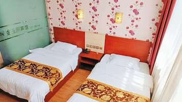Habitación de hotel con dos camas, papel tapiz floral, lámparas de noche y suelo de madera.