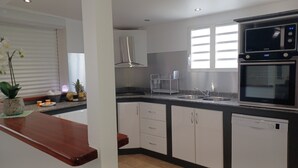 A modern kitchen with white cabinets, a stainless steel sink, and a Bosch dishwasher. - HONEY HOUSE VILLA WITH PRIVATE RIVER (Petit-Bourg)