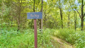Ein Wegweiser mit der Aufschrift "The Way" in einer bewaldeten Gegend.