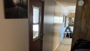A hallway with a wooden door, a small window, and a ceiling light fixture. - Cheerful 2 Bed & 1Bath unfinished home with beautiful views (Cordes Lakes)