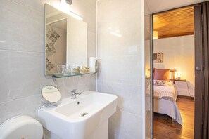 A modern bathroom with a white sink, a mirror, and a glass shelf. - Quinta Penedo das Antas (Serta)
