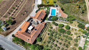 An aerial view of a property with a swimming pool, terraced garden, and a large building with a tiled roof. - Quinta Penedo das Antas (Serta)