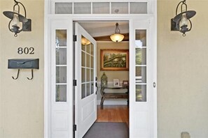 A white door with glass panels, a mailbox, and a number '802' on the wall.