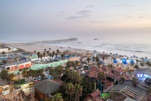 A coastal town with a pier extending into the sea, beachfront buildings, and a carnival area with balloons. - 2 Br home, Sleeps 10, 1 min walk to Rosarito Beach (Rosarito)