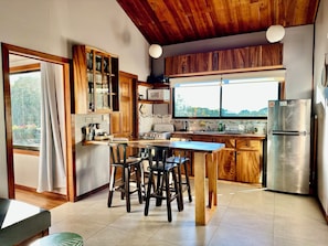 A kitchen with wooden cabinets, a stainless steel refrigerator, and a large window.