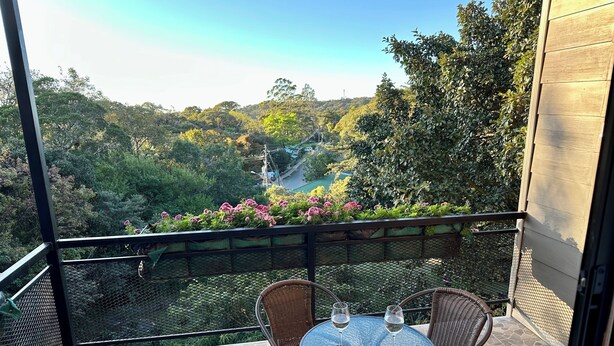 A balcony with wicker chairs, a glass table, and two wine glasses. - Wake Up with Birds in Monteverde - Forest Balcony & Walk to Reserves (Monteverde)