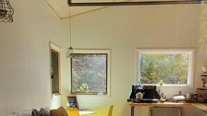 Un dormitorio acogedor con una cama, un escritorio y una ventana con vistas a zonas verdes.