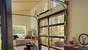 Una habitación amplia con un gran ventanal, una cama, un escritorio y una silla.
