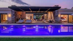 A modern outdoor pool area with lounge chairs and a covered seating area. - Stunning 11-Bd Villa, Indoor Tennis & Beach Club — Chef, Butler & Yacht Incl. (San Jose del Cabo)