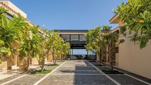 A courtyard with a modern building, potted plants, and a clear sky. - Stunning 11-Bd Villa, Indoor Tennis & Beach Club — Chef, Butler & Yacht Incl. (San Jose del Cabo)