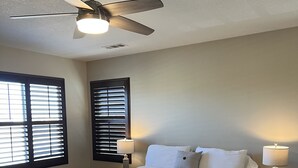 A bedroom with a bed, two bedside lamps, a ceiling fan, and a window with blinds. - Lancaster Aerospace Basecamp (Lancaster)