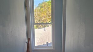 Een trap die leidt naar een balkon met uitzicht op bomen en een geplaveid gebied.