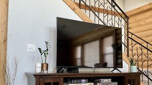 Ein Holzbauten-Möbelstück mit Fernseher, Büchern und Kamin.