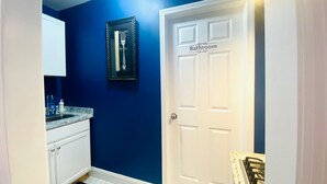 A bathroom with a white door and a framed mirror on the wall. - Sweet Home Georgia Amour (Peachtree Corners)