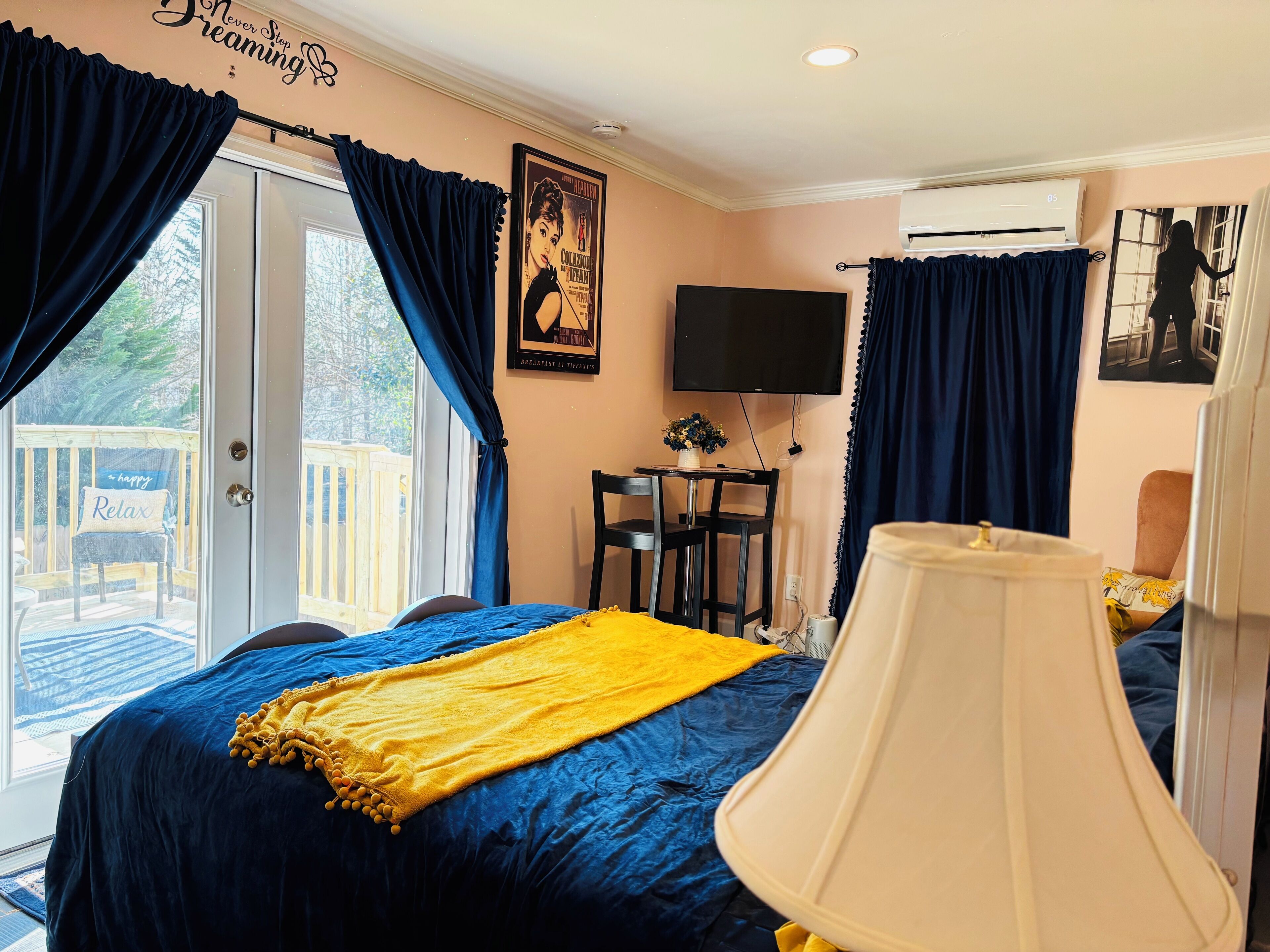 A bedroom with a bed, a TV, a desk, and a chair.