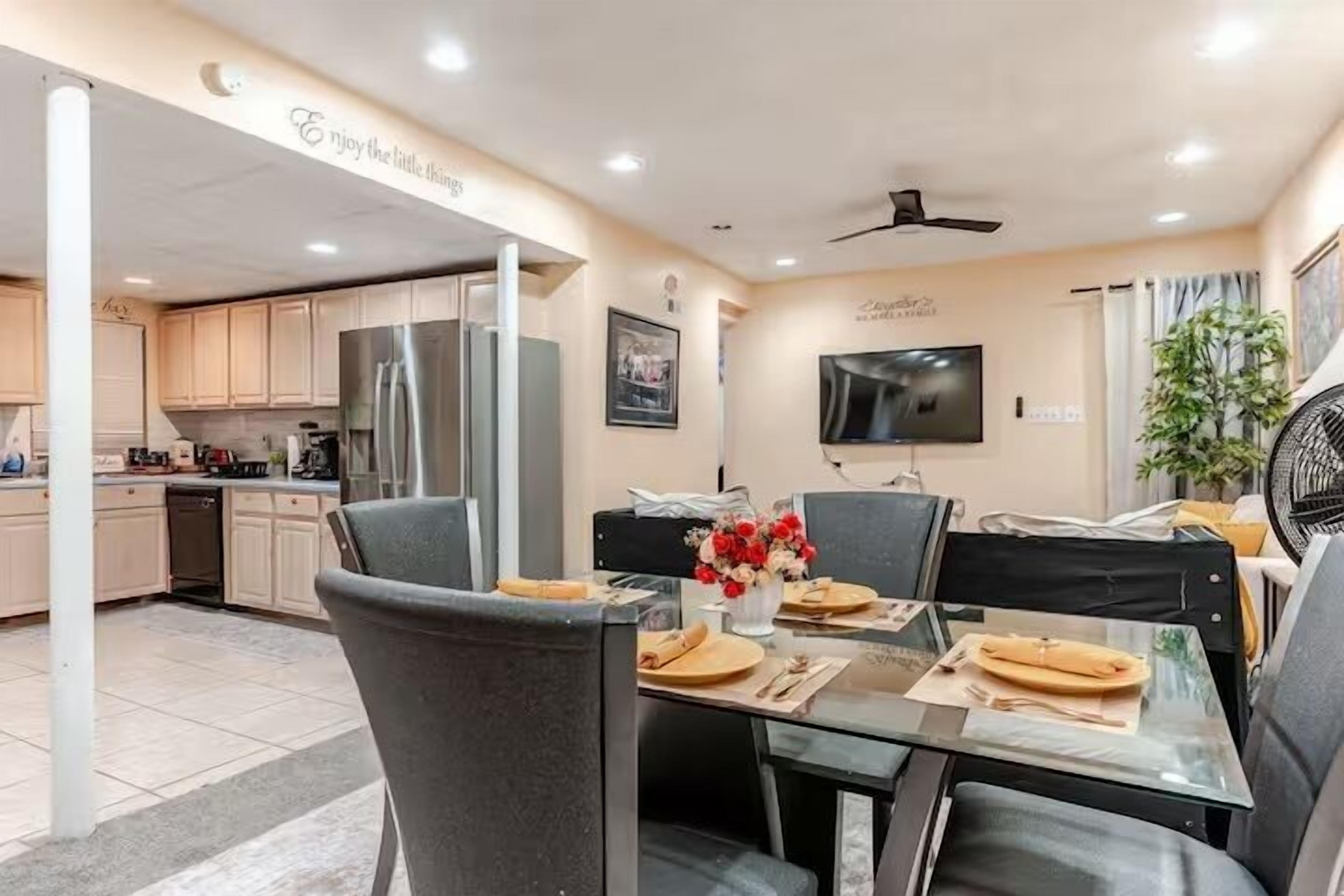 Una cocina moderna con comedor, televisión de pantalla plana y ventilador de techo.